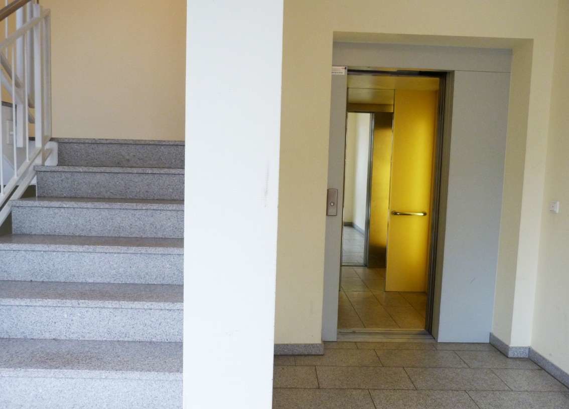 Helles Treppenhaus mit Aufzug